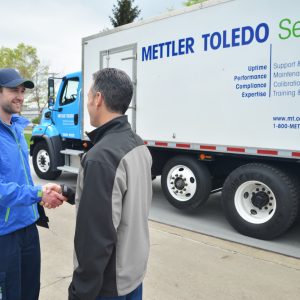 Técnico realizando mantenimiento preventivo a balanza industrial en planta de producción.