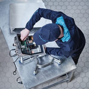 Técnico de PRECITROL realizando mantenimiento y reparación de báscula industrial.