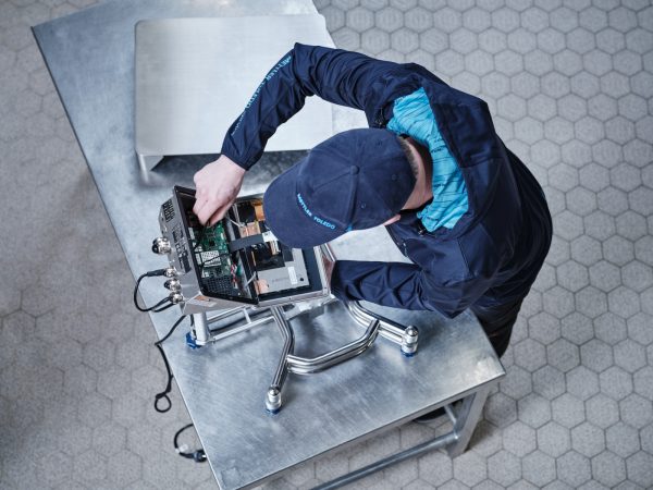 Técnico de PRECITROL realizando mantenimiento y reparación de báscula industrial.